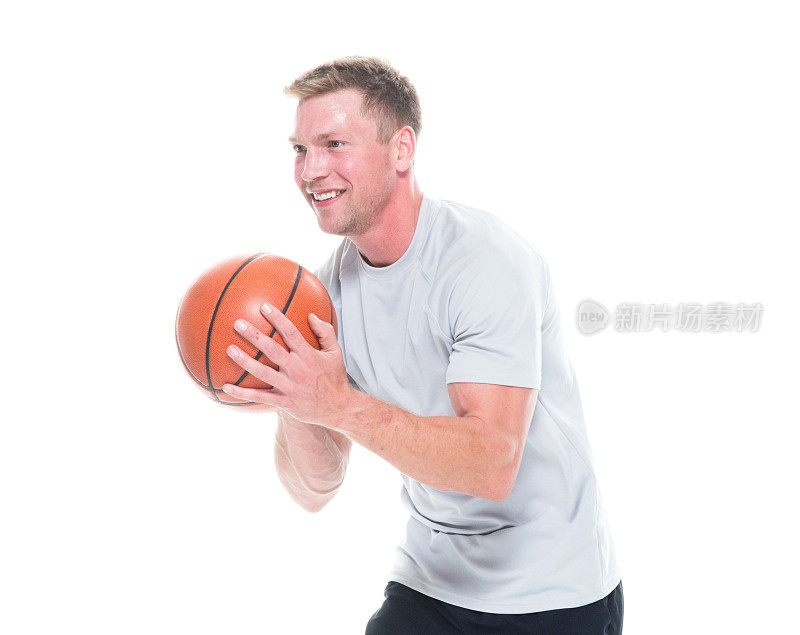 1人/一人/侧视/腰部以上20-29岁英俊的人棕色头发/短发白人男性/年轻男子运动员/运动员/篮球运动员站在白人背景前，拿着篮球